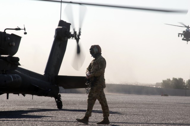 Spc. Nicholas J. Chavez, an attack helicopter repairer assigned to the Fort Bragg, North Carolina, based 82nd Combat Aviation Brigade, 82nd Airborne Division, conducts ground crew procedures for an AH-64E Apache helicopter at the Port of Shuaiba, Kuwait, Nov. 10, 2021. The Aberdeen Proving Ground, Maryland, based 1100th Theater Aviation Sustainment Maintenance Group oversaw the preparations for the retrograde of more than 30 aircraft assigned to the 82nd CAB from Nov. 7-12. Chavez and his fellow Soldiers were deployed to Afghanistan to support base closures and the U.S. military’s exit from the Hamid Karzai International Airport in Kabul.