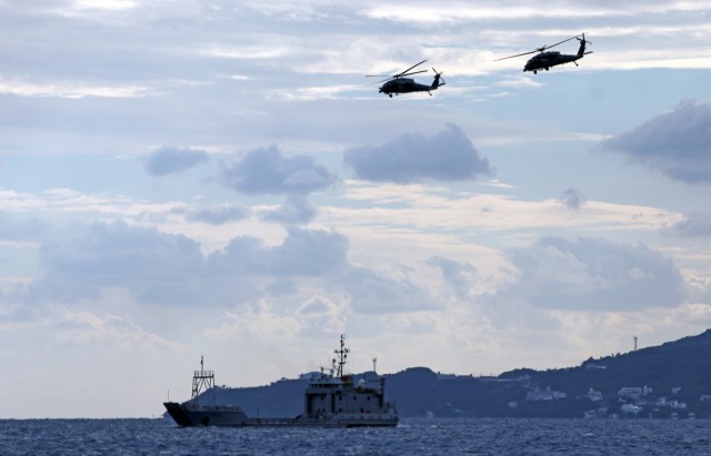 Two HH-60G Pave Hawk helicopters, assigned to the 33rd Rescue Squadron, 18th Wing, fly over United States Army Vessel Landing Craft Utility 2009 (Calaboza), 10th Support Group, during joint training off the coast of Okinawa, Japan, Nov. 10. The exercise allowed both Army and Air Force units to gain the capability of medically evacuating patients off of the LCUs from sea.