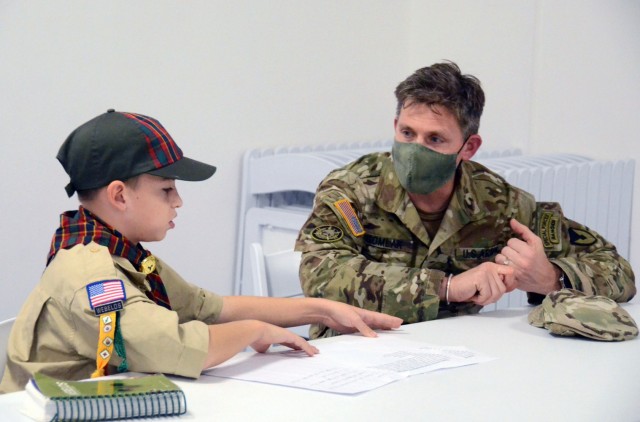 VICENZA, Italy - 10-year-old Brian Ehler asks some questions to Col. Matthew Gomlak, U.S. Army Garrison Italy commander, while focusing on his first adventure “Building a Better World”. Ehler and two other children in the Vicenza Military community had the chance to meet with Col. Gomlak at the Spiritual Life Center on Caserma Ederle Nov. 4, 2021, as part of their preparation to earn the “Arrow of Light”, the highest badge in Cub Scouting.
The Arrow of Light rank is earned by being an active member of the den for at least six months since completing the fourth grade, or for at least six months since becoming 10 years old.