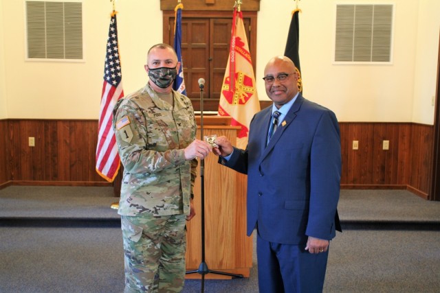 Fort McCoy Garrison Commander Col. Michael Poss presents a commander's coin of excellence Nov. 4, 2021, to retired Wisconsin State Patrol Maj. Darren Price who gave a presentation as the guest speaker for the 2021 Veterans Day Prayer Luncheon at...