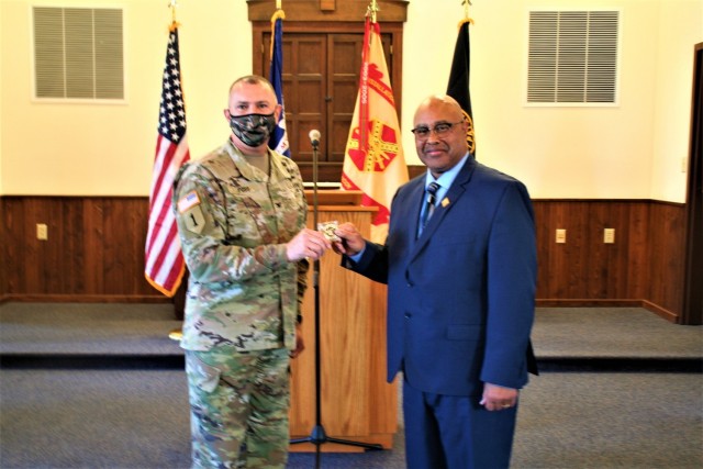 Fort McCoy Garrison Commander Col. Michael Poss presents a commander's coin of excellence Nov. 4, 2021, to retired Wisconsin State Patrol Maj. Darren Price who gave a presentation as the guest speaker for the 2021 Veterans Day Prayer Luncheon at...