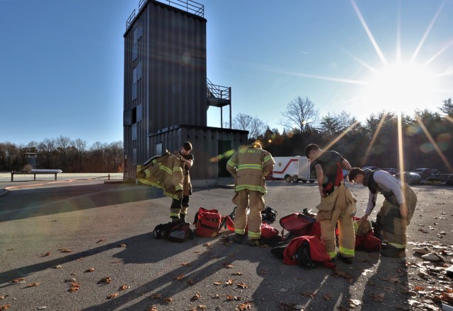 Four students get their protective fire gear on and receive instructions as they prepare for car fire training Nov. 19, 2021.