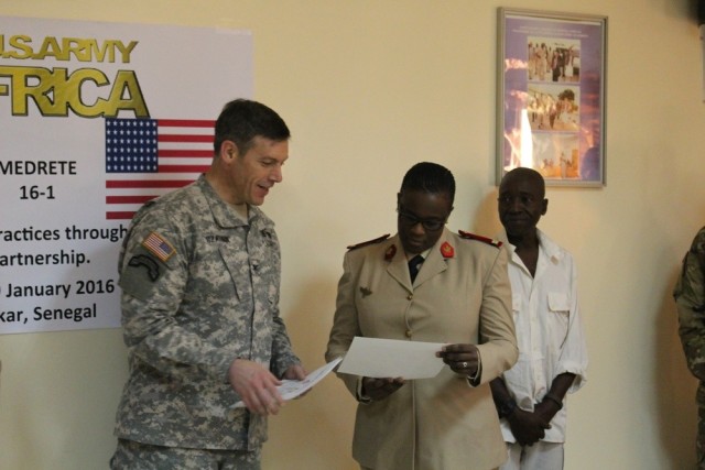 Col. Jim Czarnik, left, then the command surgeon for U.S. Army Africa, presents a certificate of appreciation to Lt. Fatou Kine Dieng, an emergency room doctor at the Hospital Military De Ouakam, Dakar, Senegal, Jan. 29, 2016. Czarnik, now the command surgeon for the Army Special Operations Command at Fort Bragg, North Carolina, recently shared his battle with transitioning to home life after multiple deployments during a panel discussion on optimizing Warfighters . The panel was hosted by the University of Southern California Center for Body Computing on Oct. 22, 2021. 