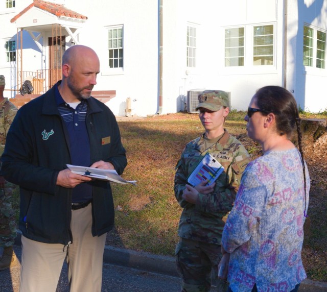 John Strange, Garrison Chief of Housing, listens to community member as she shares the importance of planting trees during a walking town hall in East Main Post II.  