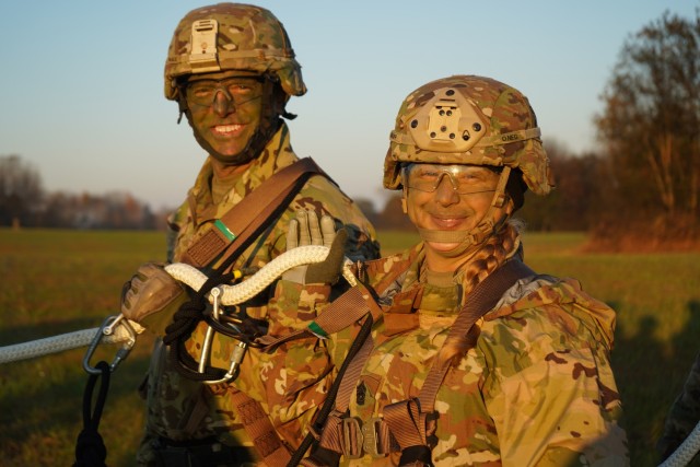 Maj. Gen. JP McGee, commanding general of the 101st Airborne Division (Air Assault), and Division Command Sgt. Maj. Veronica Knapp, smile in their harnesses as they prepare to be lifted on a rope with PV2 Rollings and seven other Soldiers during Operation LETHAL EAGLE on Fort Campbell, Kentucky. Operation LETHAL EAGLE is a 21-day, division-wide field training exercise. A tactic used for inserting or extracting Soldiers in areas where a helicopter landing zone cannot be established is commonly referred to as SPIES, Special Patrol Insertion Extraction System.