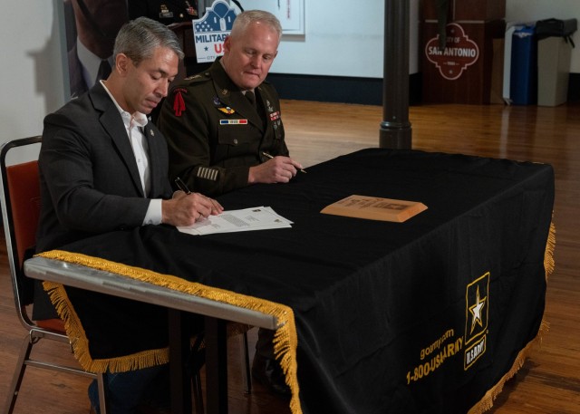 City of San Antonio Mayor Ron Nirenberg, left, signs the ceremonial agreement reaffirming the commitment between the city of San Antonio and the United States Army for the Partnership for Youth Success (PaYS) Program by signing a memorandum of agreement alongside U.S. Army North Commanding General Lt. Gen. John R. Evans, Jr., right, at the Plaza de Armas Gallery, San Antonio, Texas, Nov. 19, 2021. The U.S. Army PaYS Program guarantees Soldiers and ROTC cadets five job interviews and possible employment with the city of San Antonio government after their service in the U.S. Army.