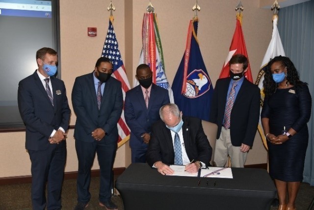 James B. Johnson, U.S. Army Space and Missile Defense Command deputy to the commander, signs the SMDC Underserved Community Cybersecurity and Engineering Education Development charter during a ceremony at the command’s Redstone Arsenal, Alabama, headquarters, Oct. 20, 2020. With him are: Matt Massey, Alabama School of Cyber Technology and Engineering; Jason Bradshaw, BDPA; Kenneth LeBlanc, LeBlanc Foundation; Dr. Tommy Morris, the University of Alabama in Huntsville; and Dr. Rosemary Hodges, Alabama School of Cyber Technology and Engineering. (U.S. Army photo by Jason Cutshaw)