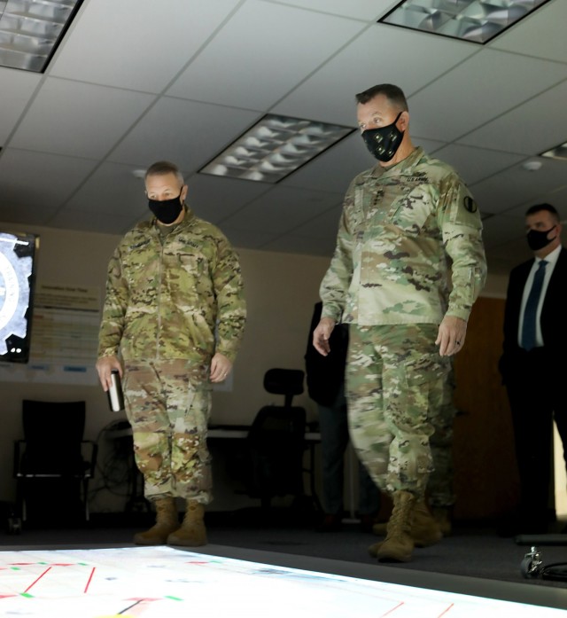 Combined Arms Center-Training Deputy Commanding General Brig. Gen. Charles Lombardo and Training and Doctrine Command Commanding General Gen. Paul E. Funk II check out the Combined Arms Rehearsal floor display using Battlefield Visualization and Interaction software at the Combined Arms Center-Training Innovation Facility during Funk’s visit to CAC-T Nov. 22, 2021. In addition to some of the synthetic training initiatives, Funk received updates on many of the projects the CAC-T subordinate organizations are working on during his visit. Photo by Tisha Swart-Entwistle, Combined Arms Center-Training Public Affairs.
