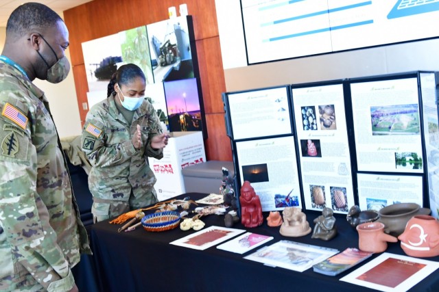 Master Sgt. Nina Clark, SDDC Military Equal Opportunity Advisor, shares information about Native American Indian artifacts from the Cahokia Mounds historical site with Sgt. 1st Class Abdullah Salahuddin during the cultural observance display at SDDC headquarters November 18, 2021.