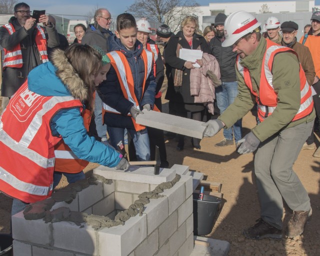 U.S. Army Corps of Engineers Project Engineer Ben Peschke helps Wiesbaden Elementary School students finish building a structure to hold a time capsule at the site of the new Wiesbaden Elementary School during construction February 14, 2019....