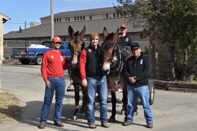 From left to right, Cpl. John Williams, Sgt. Christopher Johnson, Spc. Quinton Witt and Staff Sgt. Carlos Robles stand with the new mule team, Patsy Cline (left) and Dolly Parton (right) outside Commanding General’s Mounted Color Guard, Fort Riley, Kansas. Nov. 17.