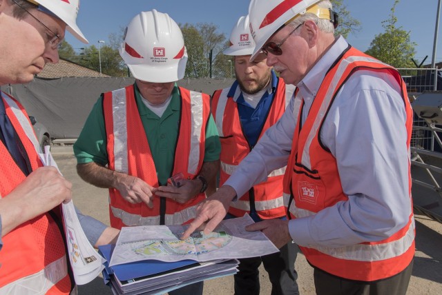 U.S. Army Corps of Engineers Resident Engineer Will Adcock, second from the right, looks over site plans for Wiesbaden Middle School during its construction in April 2018 with then U.S. Army Corps of Engineers Director of Military Programs Lloyd...