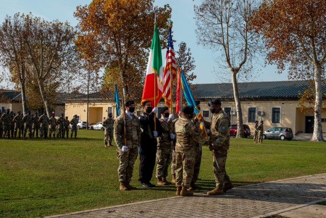 Col. Mark Denton, commander of the 207th Military Intelligence Brigade, presents the brigade colors to incoming 207th MIB Command Sergeant Major Command Sgt. Maj. Maurice Parker during an Assumption of Responsibility ceremony on Caserma Ederle, Vicenza, Italy, Nov 18, 2021. Parker previously served as a battalion command sergeant major before taking on the role of brigade command sergeant major. 