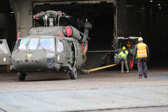 1st Air Calvary Brigade manually tow their helicopters off the Endurance Vessel after arriving at the Port in the Netherlands. Once off loaded they will be transition from travel to operational mode ready to support in Operation Atlantic Resolve.