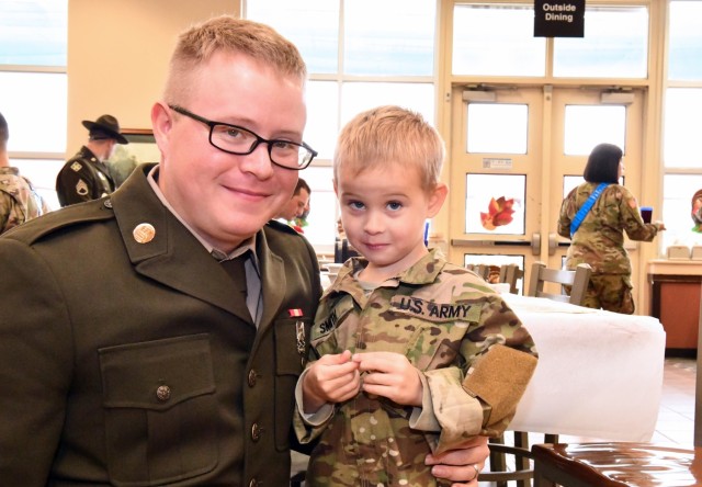 Pfc.  Dustin Smith poses with his son Roman after enjoying their Thanksgiving meal at the Rocco Dinning Facility.
