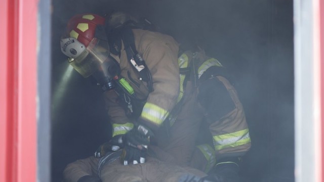 A USAG Daegu firefighter moves to extract a practice dummy during a live burn training event at Camp Carroll. The training, which was conducted 15-19 November 2021, helps prepare the firefighters for dealing with real-world scenarios.