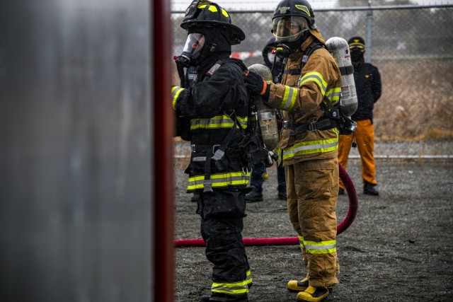 Firefighters get ready to enter a live fire training facility during a combined training exercise at Humphreys Fire and Emergency Services training area Nov. 23, 2021.