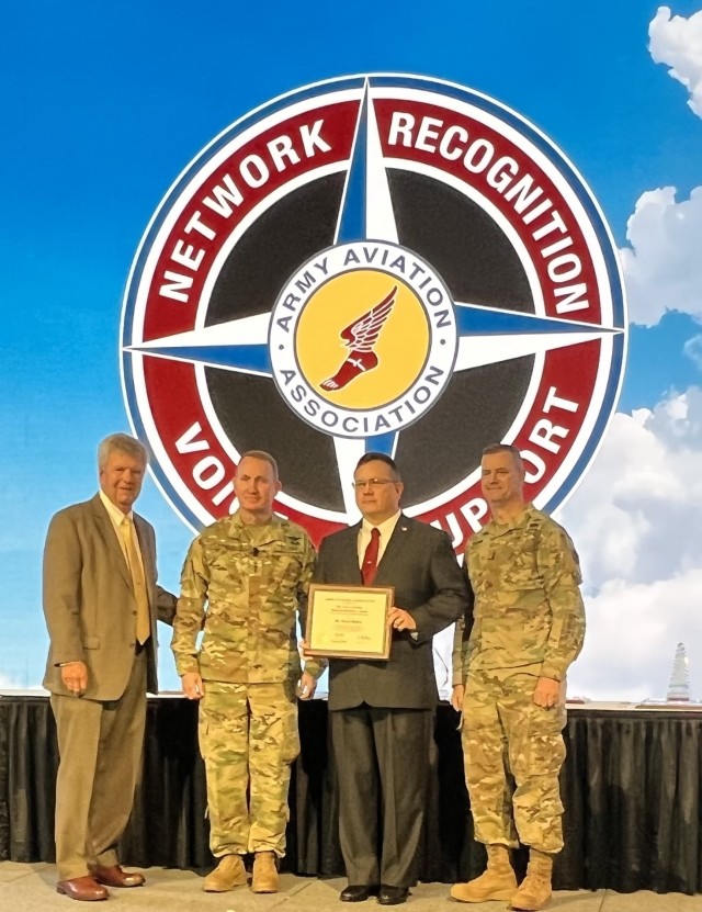 Kevin Belden, third from left, receives the Materiel Readiness Award for an individual during the Army Aviation Association of America’s Joseph P. Cribbins symposium. Looking on, from left, are retired Maj. Gen. Tim Crosby, president of the Army Aviation Association of America; Lt. Gen. Thomas Todd, deputy commander for acquisition and systems management, Army Futures Command; and Maj. Gen. Todd Royar, commander of the Aviation and Missile Command. (Photo by Shannon Murphy)