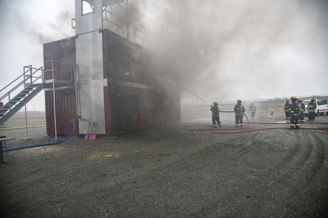 Firefighters from Cheonan Northwest, U.S. Army Garrison Humphreys, and Asan Fire Departments extinguish a class A fire during a combined live fire training at Humphreys Fire and Emergency Services training area Nov. 23, 2021.