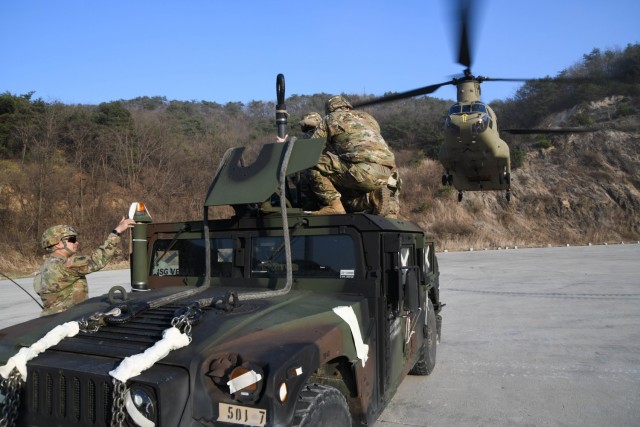 Soldiers stand by as a CH-47 Chinook helicopter approaches during during a training exercise at the Rodriguez Live Fire Complex, South Korea, on March 25, 2021.