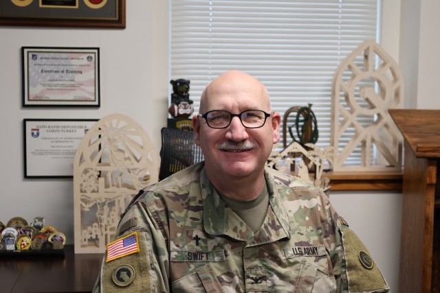 Chaplain (Col.) Douglas Swift, command chaplain, 1st Theater Sustainment Command, sits in his office amongst some of the items that he created with Baltic birch using computer numerical control equipment, Dec. 1, 2021 at Fort Knox, Kentucky. Swift does wood working to relieve stress, maintain his resiliency, and simply because he loves it.