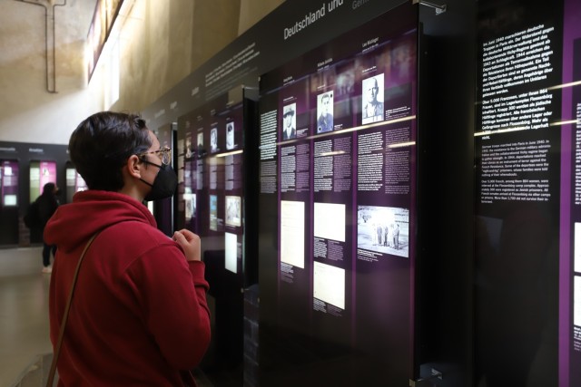 U.S. Army Sgt. Emma Rieg, from Indianapolis, Indiana, reads the stories of individual victims of Flossenburg Concentration Camp inside the former laundry house for prisoners, Flossenburg, Germany, while attending “Flossenburg Concentration Camp:...