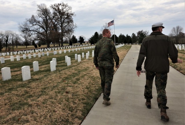 German Army liaisons Sgt. Maj. Kay Wittmann (left) and Lt. Col. Siegfried Balk walk through Fort Knox’s Main Post Cemetery Dec. 1, 2021, during their visit to honor German prisoners of war buried there.