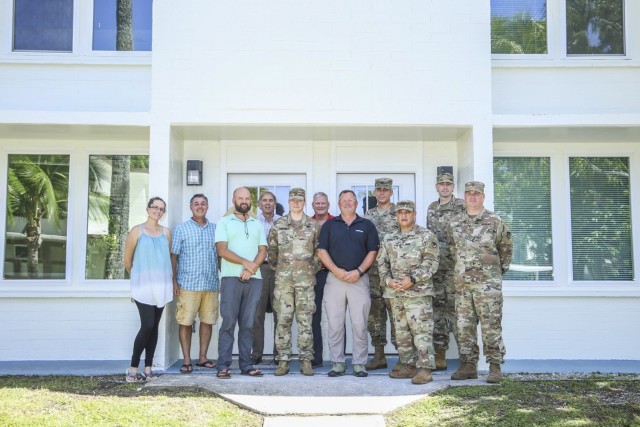 Department of the Army civilian employees, LOGCAP contract representatives and personnel from the U.S. Army Garrison-Kwajalein Atoll command team stand outside the newly renovated Quarters 436 for a ribbon-cutting ceremony, Nov. 19, 2021. Back row, from left: USAG-KA Chief Engineer Jacqueline Phelon, USAG-KA Director of Housing Scott Hill, LOGCAP Director of Public Works Carl Morris, LOGCAP Project Manager Robert Lehman, USAG-KA Commander Col. Thomas Pugsley and Maj. Scott Beck. Front row, from left: USAG-KA Director of Public Works Derek Miller, Maj. Jay Parsons, LOGCAP Director of Operations and Maintenance Clint Easton, USAG-KA Command Sgt. Maj. Ismael Ortega and Chief Warrant Officer 3 Michael Schafer.