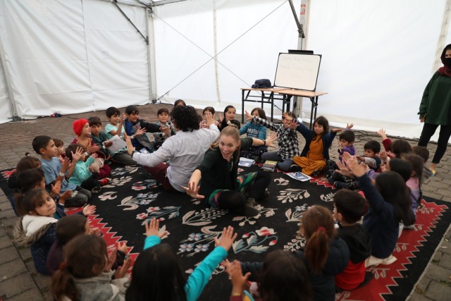 Kaiserslautern Middle School English as a Second Language Teacher Morgan Guinn leads Afghan children in a learning exercise at Rhine Ordnance Barracks. Teachers and volunteers from DODEA schools and the 21st Theater Sustainment Command provide...