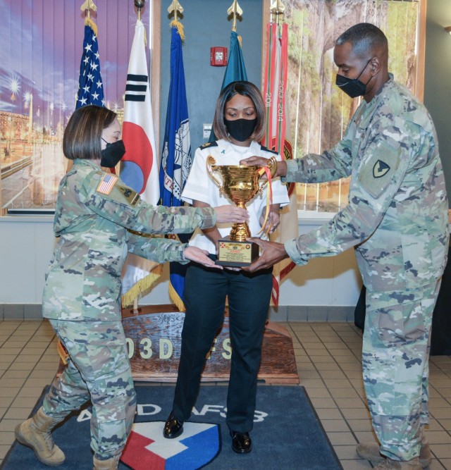 Col. Lisa Rennard, brigade commander, 403rd Army Field Support Brigade, and Command Sgt. Maj. Christopher Reaves, 403rd AFSB brigade command sergeant major, present the Connelly Trophy to Sgt. 1st Class Dianna Franklin, Sustainer Grill Warrior Restaurant manager, in recognition of the Sustainer Grill being named the top Warrior Restaurant on the Peninsula in the 54th Annual Philip A. Connelly Award Competition Military Garrison Category during at Camp Henry, South Korea, Nov. 24.