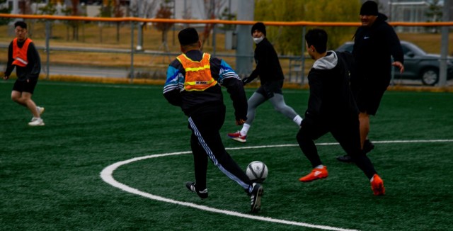 American and Korean Augmentation to the U.S. Army Soldiers from Headquarters and Headquarters Company, U.S. Army Garrison Humphreys drive the soccer ball down the field during a teambuilding soccer game Nov. 24, 2021.