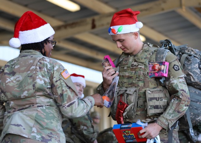 FORT KNOX, Ky. - Pfc. Alex Parker, from St. Louis, Missouri, hands his donations to Cpl. Ashanti Bracey, from Virginia Beach, Virginia, who accepted donations on behalf of the local Red Cross at Fort Knox, Kentucky, Dec. 2. Dozens of V Corps Soldiers attended a ruck march toy drive to boost holiday spirit and spread cheer to families and children in need in the local community. (U.S. Army photo by Pfc. Devin Klecan/released)