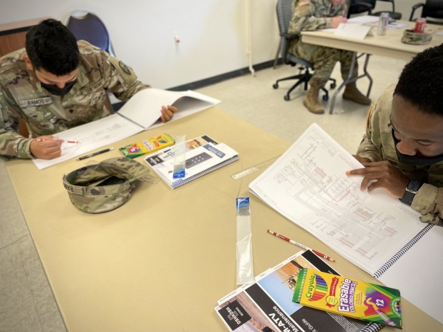 Spc. Juan Ramos and Pfc. Garrok Lias, 303rd Military Intelligence Battalion, 504th Expeditionary MI Brigade, trace battery power on a schematic, Nov. 30, 2021, Fort Hood, Texas. Understanding how to read a schematic is a critical skill to learn troubleshooting. (U.S. Army photo by Sgt. Melissa N. Lessard)