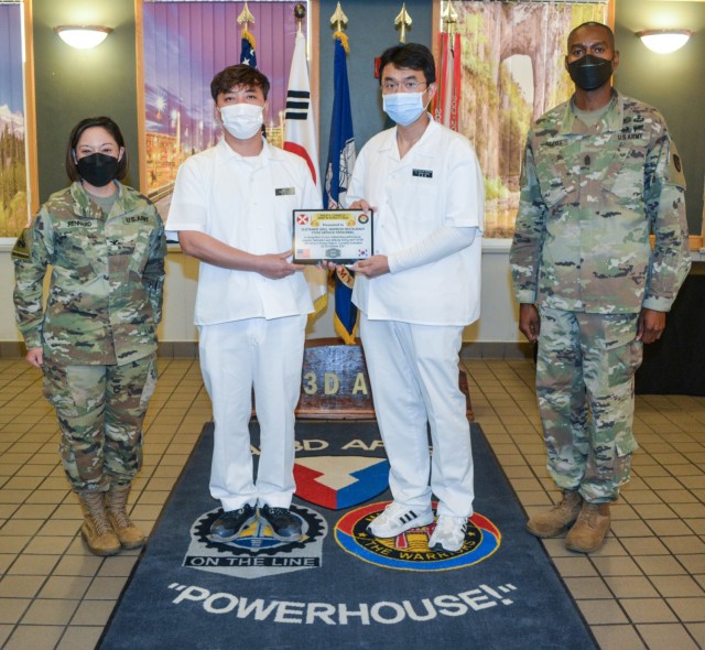 Col. Lisa Rennard, brigade commander, 403rd Army Field Support Brigade, and Command Sgt. Maj. Christopher Reaves, 403rd AFSB brigade command sergeant major, pose with staff members Kim, Yong U. (left) and Yi, Sang Chol, during a ceremony recognizing the Sustainer Grill as the top Warrior Restaurant on the Peninsula in the 54th Annual Philip A. Connelly Award Competition Military Garrison Category at Camp Henry, South Korea, Nov. 24.