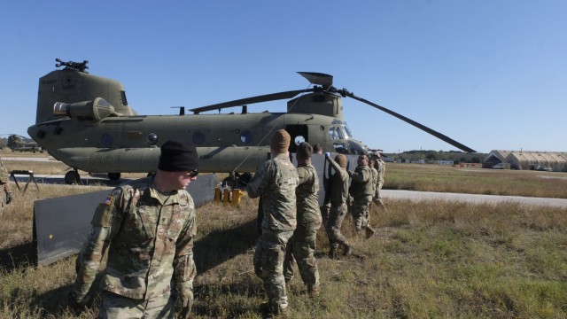 U.S. Army Spc. Drew Gillaspie, a CH-47 helicopter repairer with Delta Company, 7-158th General Support Aviation Battalion, 11th Expeditionary Combat Aviation Brigade, leads a group of Soldiers as they carry part of a CH-47 Chinook helicopter at North Fort Hood, TX on November 19, 2021. (U.S. Army photo by Cpl. Nicholas Fuel)