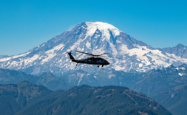 An all-female flight crew assigned to 16th Combat Aviation Brigade, flies in front of Mount Rainier, Wash., on Jul. 29, 2021.  Flight crews comprising of all women are uncommon due to the low number of females in Army aviation. (U.S. Army photo by Capt. Kyle Abraham, 16th Combat Aviation Brigade)
