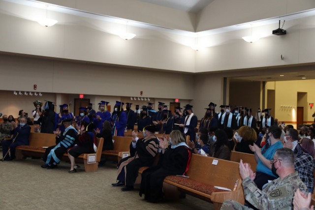 The graduating students in the Fort Sill multi-school graduation ceremony stand and move their tassels to the left side of the cap at the conclusion of the graduation ceremony Dec. 2, 2021 at the Cache Creek Chapel. The ceremony was hosted on Fort...