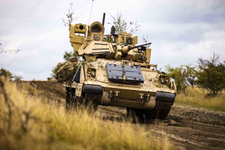 Soldiers move an Army M2 Bradley Fighting Vehicle toward an objective during a multinational situational training exercise in Cincu, Romania, Sept. 23, 2021.