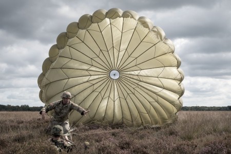 A U.S. Army paratrooper helps a Dutch paratrooper control his parachute in the Netherlands during Falcon Leap, Sept. 16, 2021. Falcon Leap is NATO&#39;s largest technical airborne exercise, with more than 1,000 paratroopers from 12 different nations training with one another&#39;s equipment for two weeks.