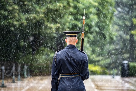 A soldier assigned to the 3rd U.S. Infantry Regiment, known as “The Old Guard,” walks the mat at the Tomb of the Unknown Soldier during a rainstorm at Arlington National Cemetery in Virginia, July 8, 2021.