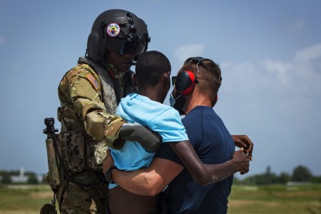 Army Capt. Alix Idrache, a pilot and future operations planner — originally from Haiti — with the 1st Battalion, 228th Aviation Regiment, Joint Task Force Bravo, delivers a patient to Zach Pendergast, a paramedic emergency medical service...