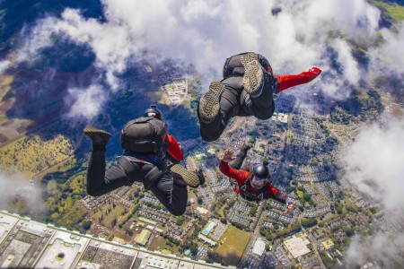 Soldiers participate in a tandem jump with the U.S. Army Special Operations Command&#39;s parachute demonstration team, the Black Daggers, during Tropic Lightning Week at Schofield Barracks, Hawaii, Oct. 5, 2021. The week includes competitive events between battalions throughout the 25th Infantry Division.