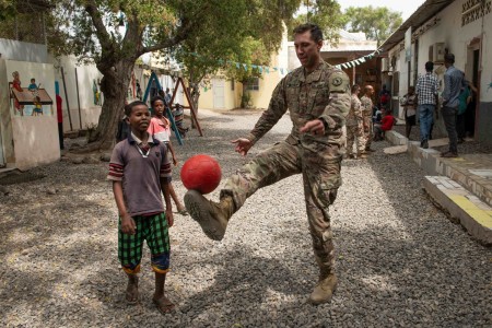 U.S. Army Staff Sgt. Ryan Rodehorstplays soccer with a child at Caritas Orphanage, Djibouti, July 15, 2021.