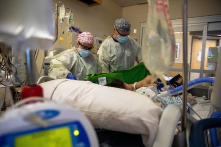 Army  Capts. Jason Webb (right) and Corrine Brown (left), critical care nurses with the 627th Hospital Center, prepare to move a COVID-19 positive patient during COVID-19 response operations at Kootenai Health Regional Medical...