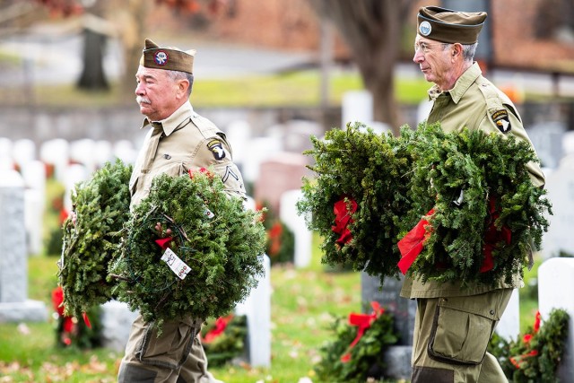 A cadet and veterans from the 101st Airborne Division (Air Assault) help with the placement on wreaths on every grave Saturday at the West Point Cemetery.