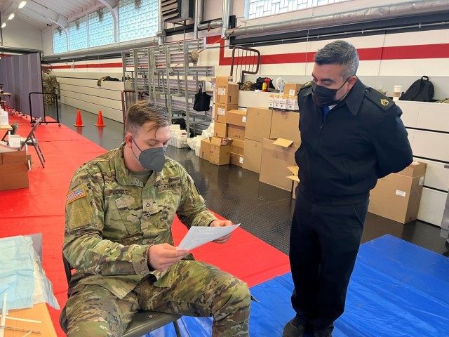 PFC Timothy Puckett, 512th Field Hospital, ensures eligibility for Staff Sgt. Jorge Morales, 55QM, 16th Sustainment Brigade, during a COVID-19 Booster Rodeo at Kleber Gym, Kaiserslautern, Germany, on December 8, 2021. Soldiers from the 30th...