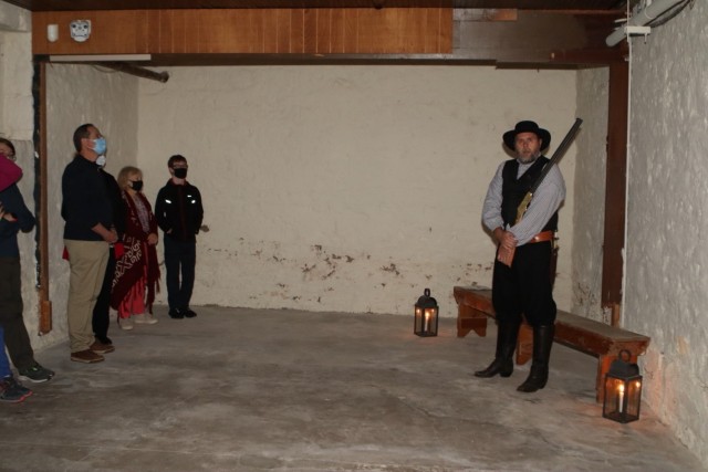 A deputy U.S. Marshal (Dr. Scott Neel, Fort Sill Historic Landmark and Museum director/curator) tells visitors about the conditions in the Guardhouse and prisoner treatment in the 1870s during the Fort Sill Old Post Quadrangle Candlelight Stroll Dec. 5, 2021.