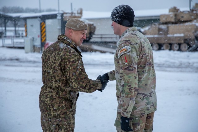 Latvian Land Forces Mechanized Infantry Brigade Commander Col. Sandris Gaugers (left) recognizes U.S. Army Capt. Tyler Kellogg (right), commander of Charlie Company, 3rd Battalion, 66th Armored Regiment, 1st Armored Brigade Combat Team, 1st Infantry Division, for his outstanding effort during Winter Shield 2021 at Camp Ādaži, Ādaži, Latvia, Dec. 4, 2021. Winter Shield is a combined multinational forces exercise that strengthens ties and increases lethality of NATO allies and partner nations. (U.S. Army photo by Spc. Michael Baumberger/RELEASED)