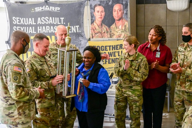 The facility manager of the 369th Adjutant Battalion dining facility accepts a trophy Dec. 2, 2021, from the Fort Jackson, South Carolina command team after being named one of the best facilities during the annual Thanksgiving DFAC Competition.