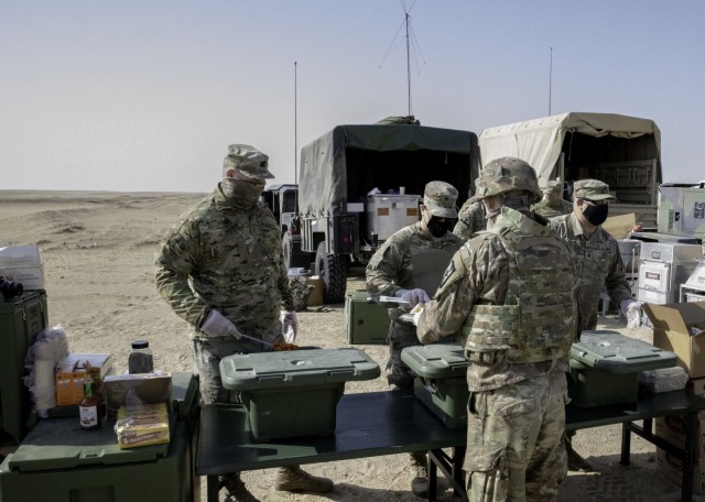 Army Capt. Edward Raschen (left), commander of Forward Support Company, 891st Engineer Battalion, serves food to his Soldiers during training Dec. 30, 2020, at Udari Range, Kuwait. 